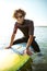 Surfer sitting on his surf board in water wearing swimsuit