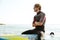 Surfer sitting on surf board with hands crossed in ocean