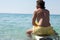 Surfer sitting on surfboard at seacoast