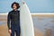 Surfer standing on the beach with beautiful ocean horizon on background