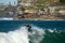 Surfer standing on the shortboard and catching waves, scattering water around