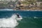 Surfer standing on the shortboard and catching waves, scattering water around