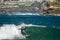 Surfer standing on the shortboard and catching waves, scattering water around