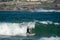 Surfer standing on the shortboard and catching waves, scattering water around