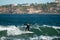 Surfer standing on the shortboard and catching waves, scattering water around