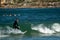 Surfer standing on the shortboard and catching waves, scattering water around