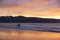 Surfer at sunset on 90 Mile Beach, Ahipara, New Zealand