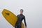 Surfer With Surfboard Looking Away Against Sky At Beach