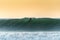 A surfer surfing at Betty`s Bay beach at sunset in the Western Cape, South Africa