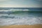 Surfer swimming breaking wave coming to shore on sandy beach of atlantic coast, capbreton, france