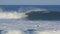 Surfer switches surfboards while riding a wave at pipeline