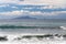 The surfer takes a wave, on a surfboard, slides along the wave, in the background of the mountain, Sorrento Italy