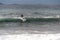 The surfer takes a wave, on a surfboard, slides along the wave, in the background of the mountain, Sorrento Italy