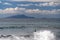 The surfer takes a wave, on a surfboard, slides along the wave, in the background of the mountain, Sorrento Italy