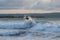 Surfer with a tanned body performs a trick on a short board - a jump over the waves.