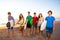 Surfer teen boys girls group walking on beach