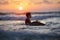 Surfer waiting in the line up for a wave at sunrise or sunset