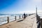 Surfer Waves Walking Pier