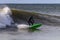 Surfer in a wetsuit carving through ocean waves. Winter cold weather surfing - Long Beach, NY