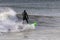 Surfer in a wetsuit carving through ocean waves. Winter cold weather surfing  - Long Island NY