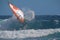 Surfer windsurfing in the waves, performing a cutback with spray