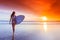 Surfer woman on beach at sunset