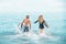 Surfers at the beach- Smiling couple of surfers swiming and having fun in summer. Extreme sport and vacation concept