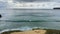 Surfers catch large waves at the beach at Praia do Beliche in the Algarve region of Portugal