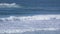 Surfers chasing the Waves crashing along shoreline in Northern California at Big Sur Monterey area during tide