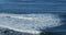 Surfers in the ocean near a rocky coastline