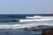 Surfers practising surfing on surfboards and Atlantic Ocean panorama in holiday resort Playa de las Americas on Canary Island