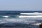 Surfers practising surfing on surfboards and Atlantic Ocean panorama in holiday resort Playa de las Americas on Canary Island