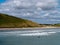 Surfers ride the waves in Clonakilty on a summer. Water sports in Ireland, landscape. The Irish