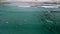 Surfers Riding Waves In The Beach with Clear Water. - aerial