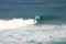 Surfers riding on white barrel breaking wave
