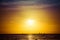 Surfers and sail boats in the ocean during sunset