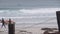 Surfers on sandy ocean beach. People surfing, autumn or winter California waves.