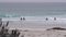 Surfers on sandy ocean beach. People surfing, autumn or winter California waves.