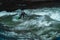 Surfers surf on the Eisbach, a cold icy stream in Munich, during a sunny day in winter