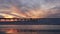 Surfers surfing by pier. Ocean water waves, people and sky at sunset. California