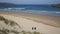 Surfers towards camera Crantock bay and beach North Cornwall England UK