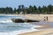 Surfers walk past Seven Star Rock at Arugam Bay on the east coast of Sri Lanka.