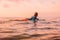 Surfgirl with perfect body on a surfboard floating in ocean