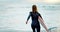 Surfing, beach and woman with surfboard running for water sports, fitness and freedom by ocean. Nature, travel and back