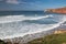 Surfing breaking waves in colorful scenic seascape of atlantic coastline