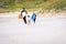 Surfing family with surfboard is walking on the sandy beach