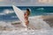 Surfing girl on a beach with white board