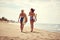 Surfing lifestyle. Surfer girls walking with board on the sandy beach