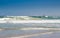 Surfing at Melkbosstrand beach with Koeberg Nuclear Power Station in background