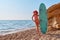 Surfing sport, adventure time and holiday trip idea, copy space. Beautiful woman posing in swimsuit and hat on beach.